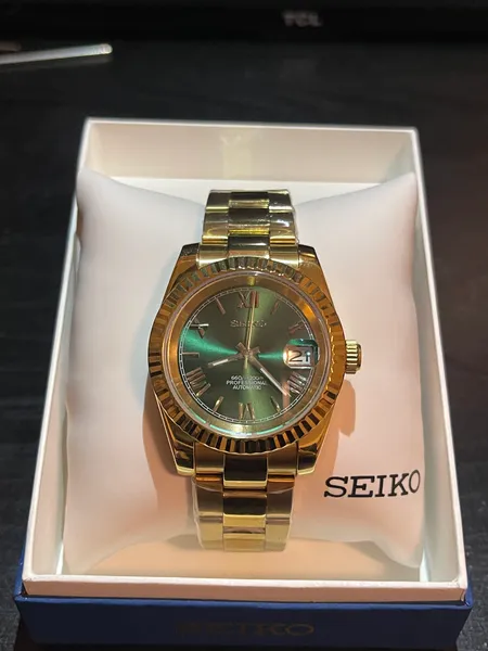 Gold-tone Datejust with a green dial in its presentation box